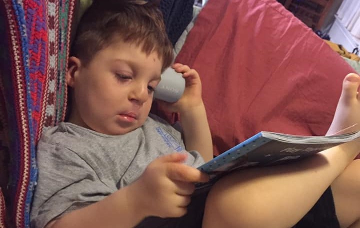 A young boy looks at a book.