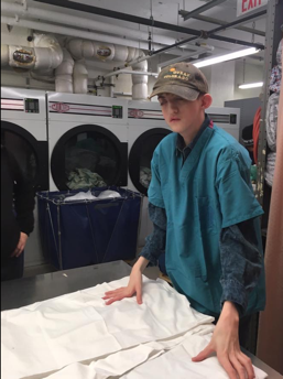 Young boy folding laundry.