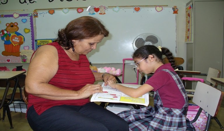 Young girl working with teacher.