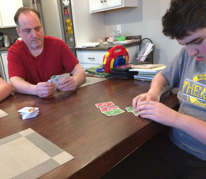 A family plays a braille uno card game.