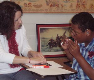 An intervener working with a student at their desk.
